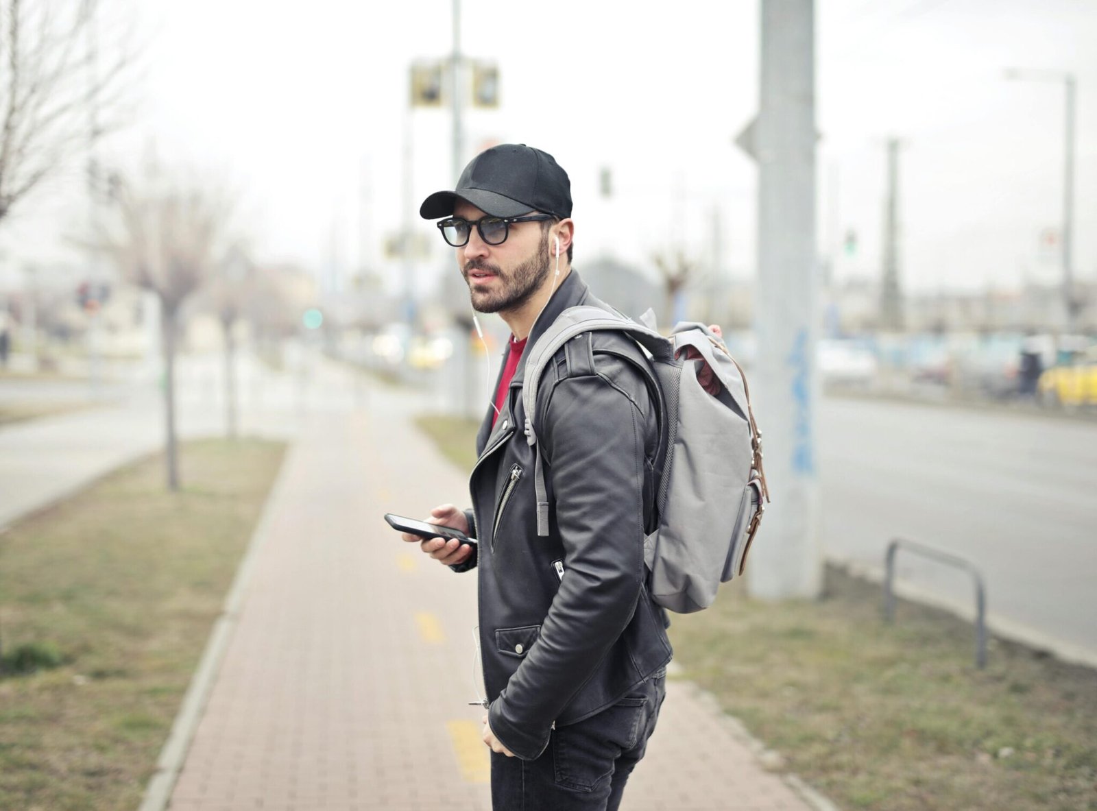 Home 3 A fashionable young man in Budapest checking his smartphone on a busy street.